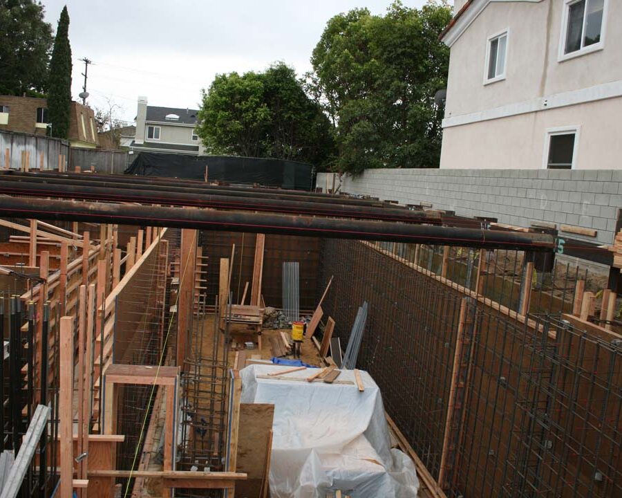 Form work and ironwork for a poured in place retaining wall and basement. Pacificland Constructors