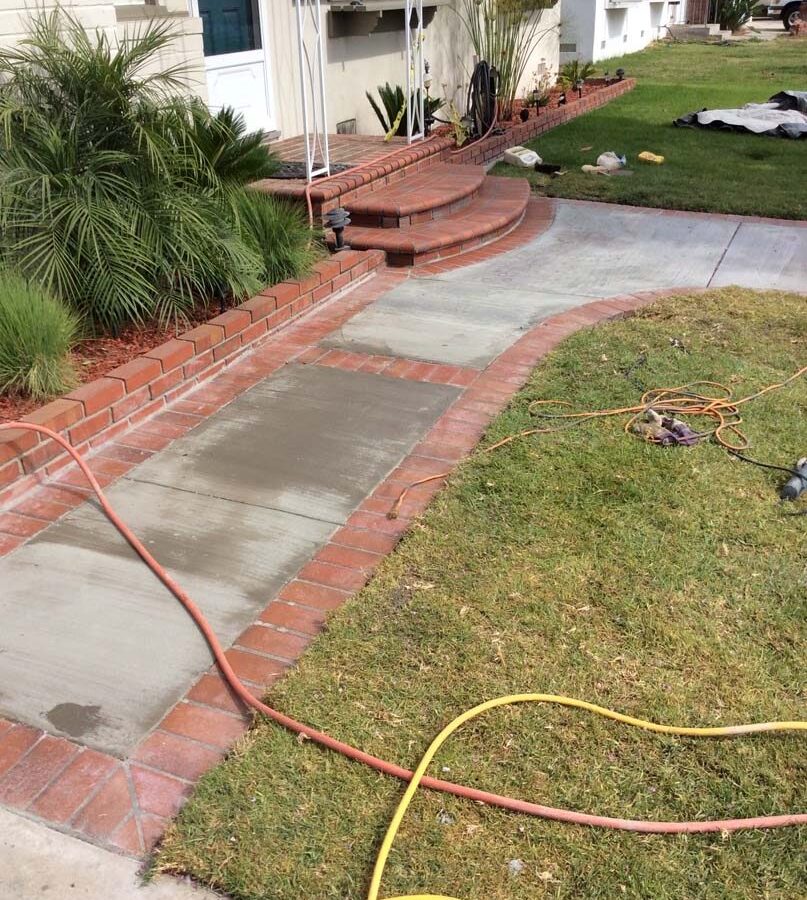 New walkway entrance creating a dry access between the driveway and front door. This walkway has brick ribbon and a nice brick front porch landing. Pacificland Constructors