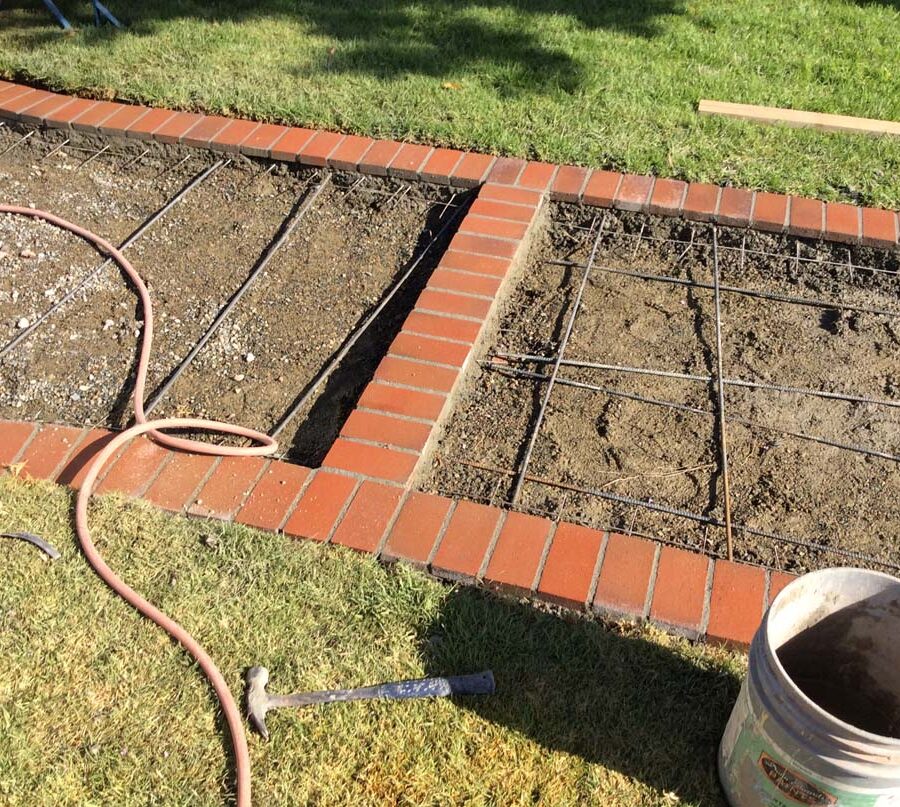 Construction of curved walkway entrance with brick ribbon and a nice brick front porch landing. The reinforced flatwork will be poured with gray concrete. Pacificland Constructors