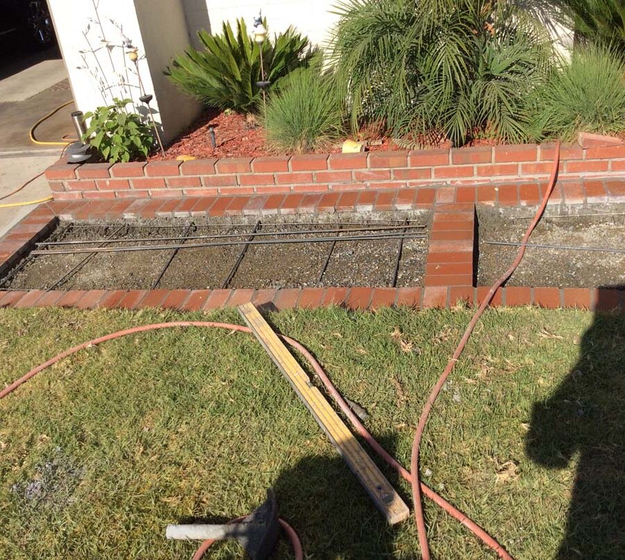 Construction of curved walkway entrance with brick ribbon and a nice brick front porch landing. The reinforced flatwork will be poured with gray concrete. Pacificland Constructors