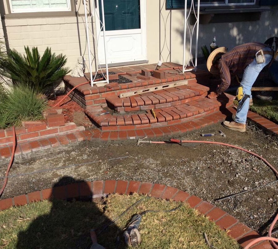 Construction of curved walkway entrance with brick ribbon and a nice brick front porch landing. The reinforced flatwork will be poured with gray concrete. Pacificland Constructors