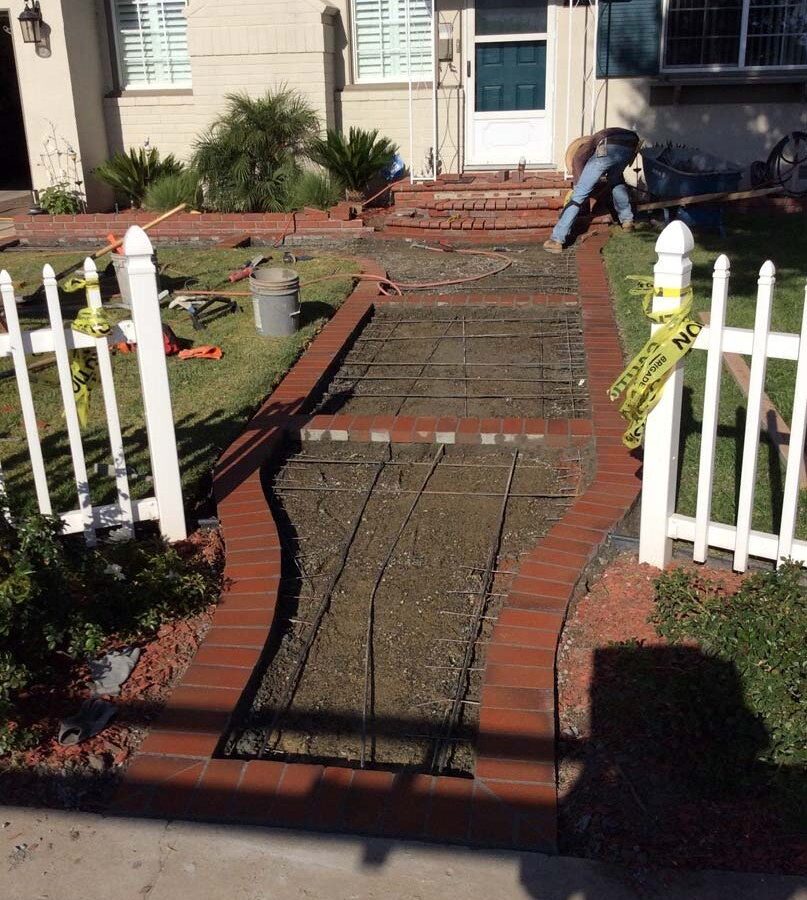 Construction of curved walkway entrance with brick ribbon and a nice brick front porch landing. The reinforced flatwork will be poured with gray concrete. Pacificland Constructors