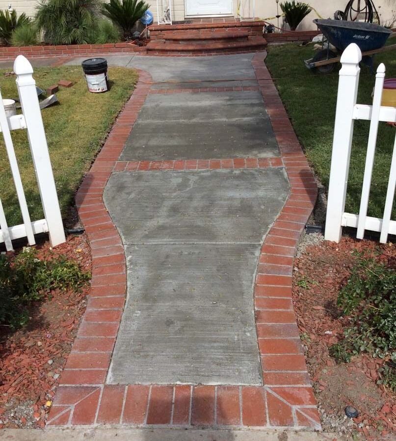 Beautiful curved walkway entrance with brick ribbon and a nice brick front porch landing. Pacificland Constructors