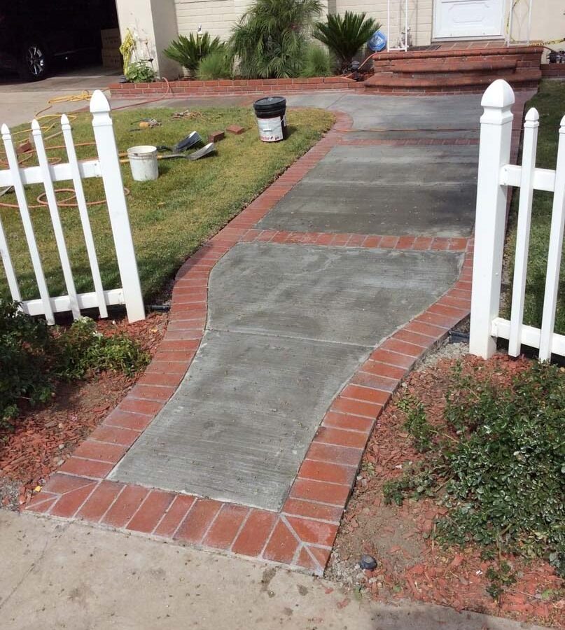 Beautiful curved walkway entrance with brick ribbon and a nice brick front porch landing. Pacificland Constructors