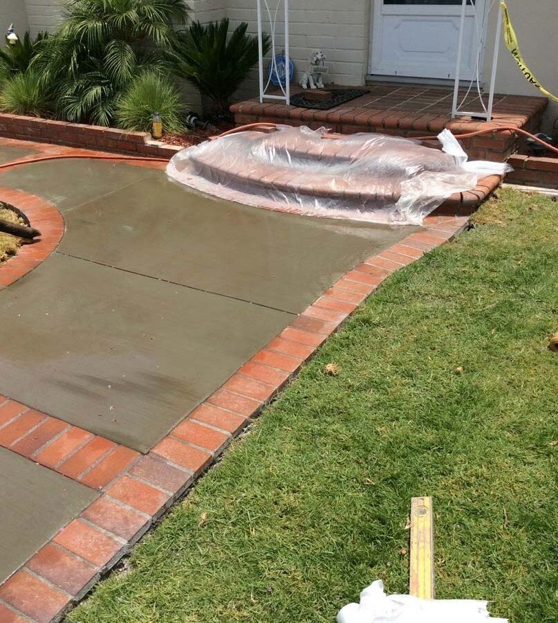 Beautiful curved walkway entrance with brick ribbon and a nice brick front porch landing. Pacificland Constructors