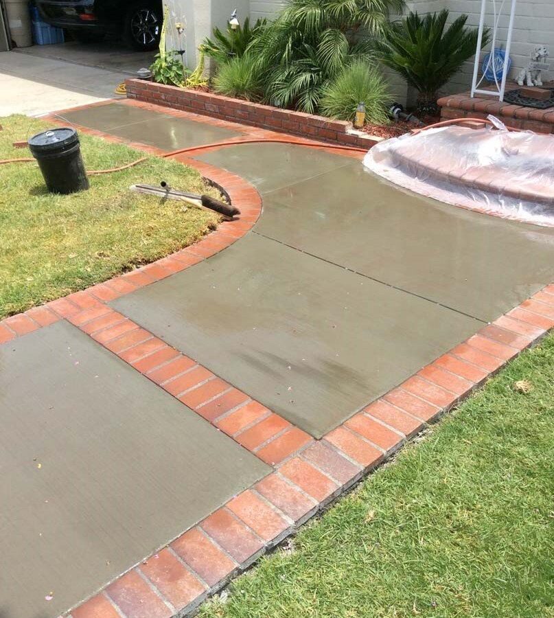 Beautiful curved walkway entrance with brick ribbon and a nice brick front porch landing. Pacificland Constructors