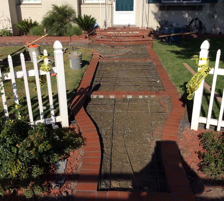 Construction of curved walkway entrance with brick ribbon and a nice brick front porch landing. The reinforced flatwork will be poured with gray concrete. Pacificland Constructors