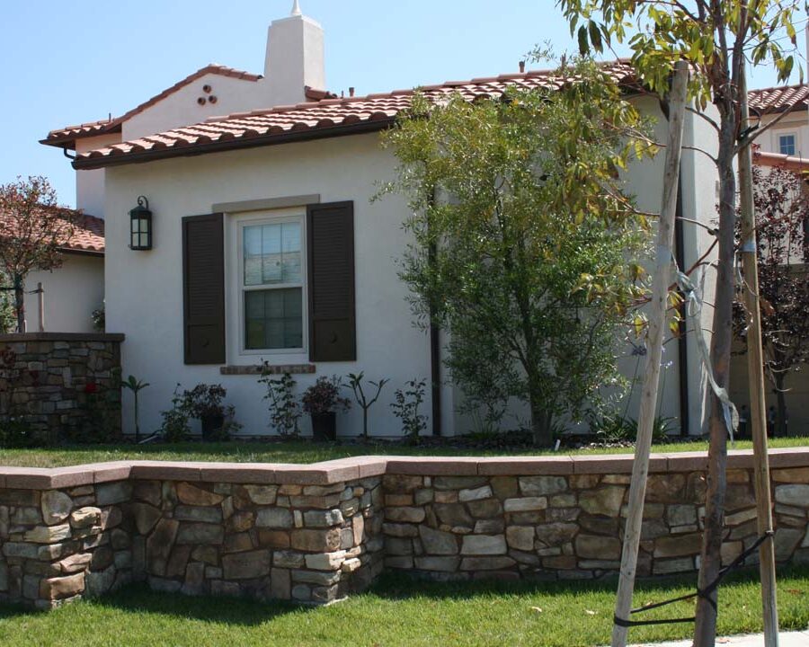 New stone veneer on the main entrance solidifies the Spanish architectural theme of the home. Pacificland Constructors