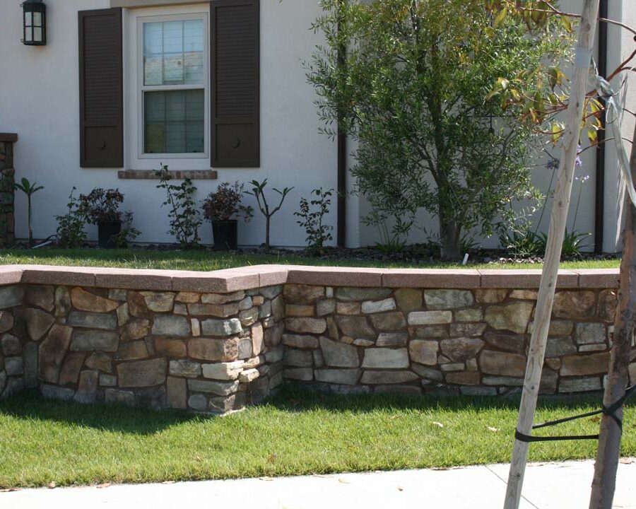 Concrete poured wall cap poured over a stone veneer concealing the CMU planter. Pacificland Constructors