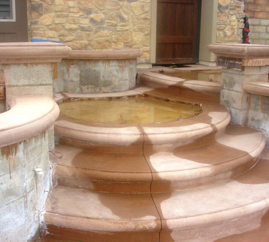 Construction of a new home entrance. New bull-nosed poured steps and CMU planters with poured wall cap prior to putting stone veneer on these planters. It had rained that weekend making a puddle where flagstone flatwork will be. Pacificland Constructors