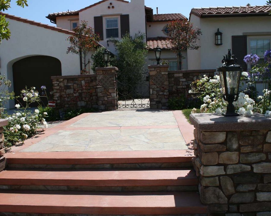 New Steps and flagstone flatwork with concrete ribbons for the entrance of this home. Stone veneered pilasters and colored wall caps create a bold vintage Spanish theme. Pacificland Constructors