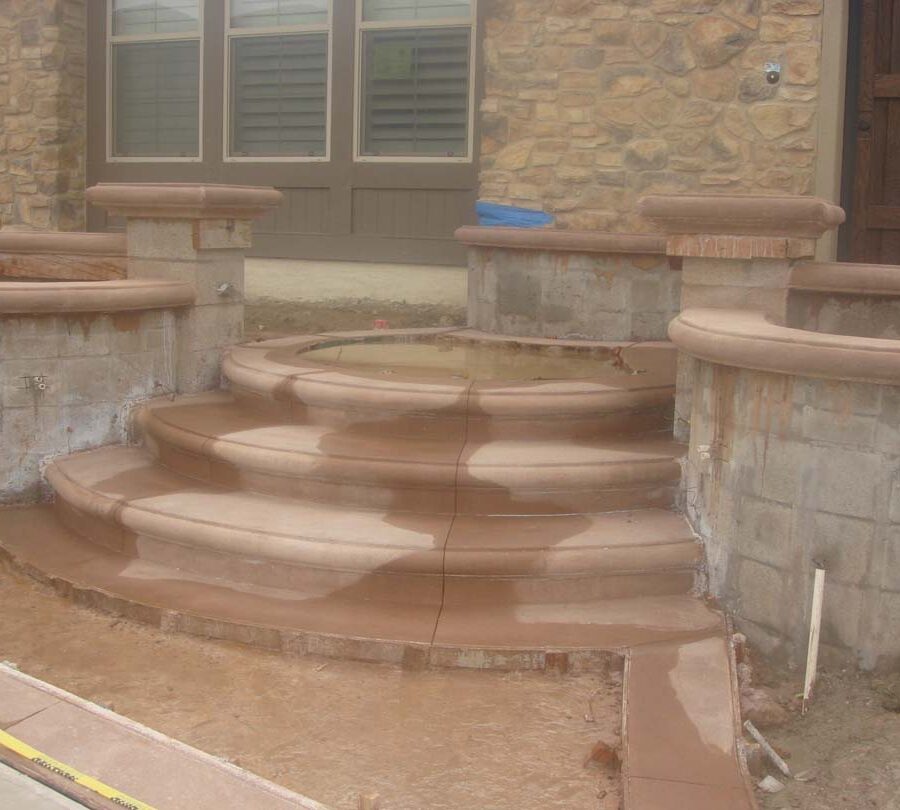 Construction of a new home entrance. New bull-nosed poured steps and CMU planters with poured wall cap prior to putting stone veneer on these planters. It had rained that weekend making a puddle where flagstone flatwork will be. Pacificland Constructors