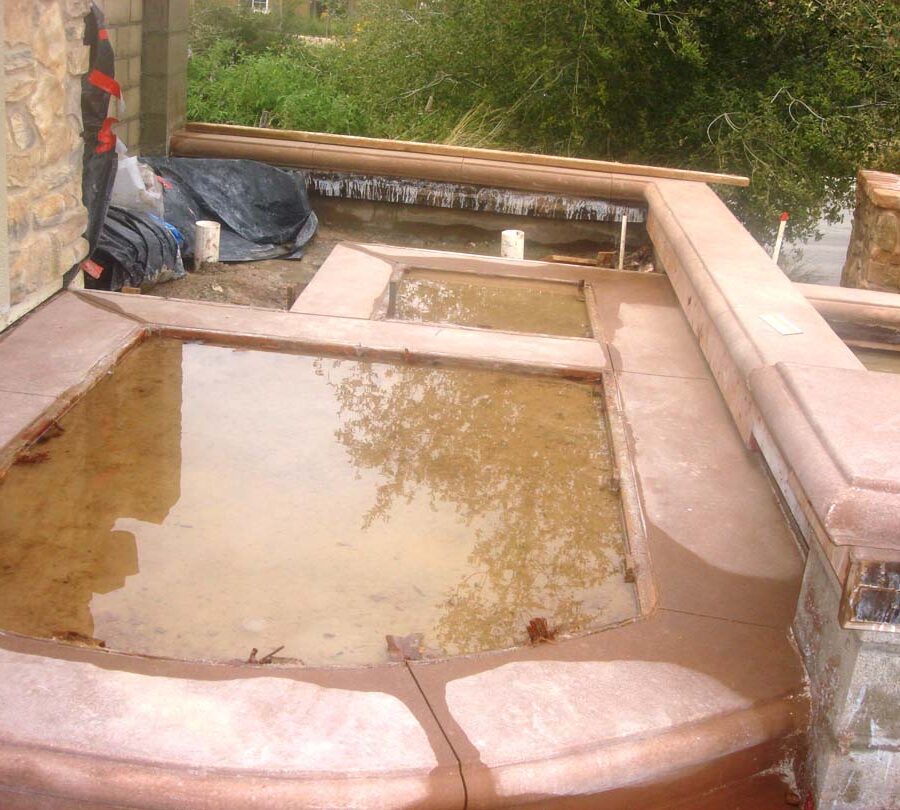 Construction of a new home entrance. New bull-nosed poured steps and CMU planters with poured wall cap prior to putting stone veneer on these planters. It had rained that weekend making a puddle where flagstone flatwork will be. Pacificland Constructors