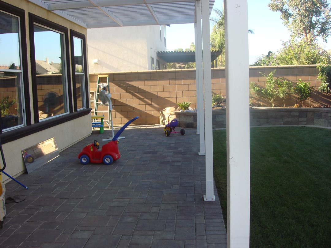 New pavers for the covered patio and stone veneer to conceal CMU planters to give the home an architecturally vintage look. Pacificland Constructors