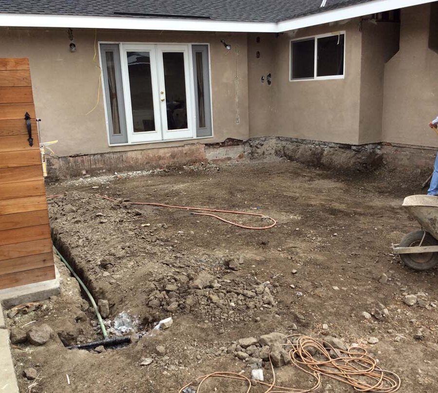 Grading and drainage installation for a new concrete backyard patio with an architecturally nature-friendly theme. Pacificland Constructors