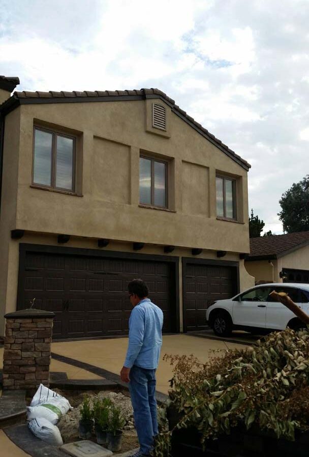 New colored concrete driveway with dark contrasting concrete ribbons. Pacificland Constructors