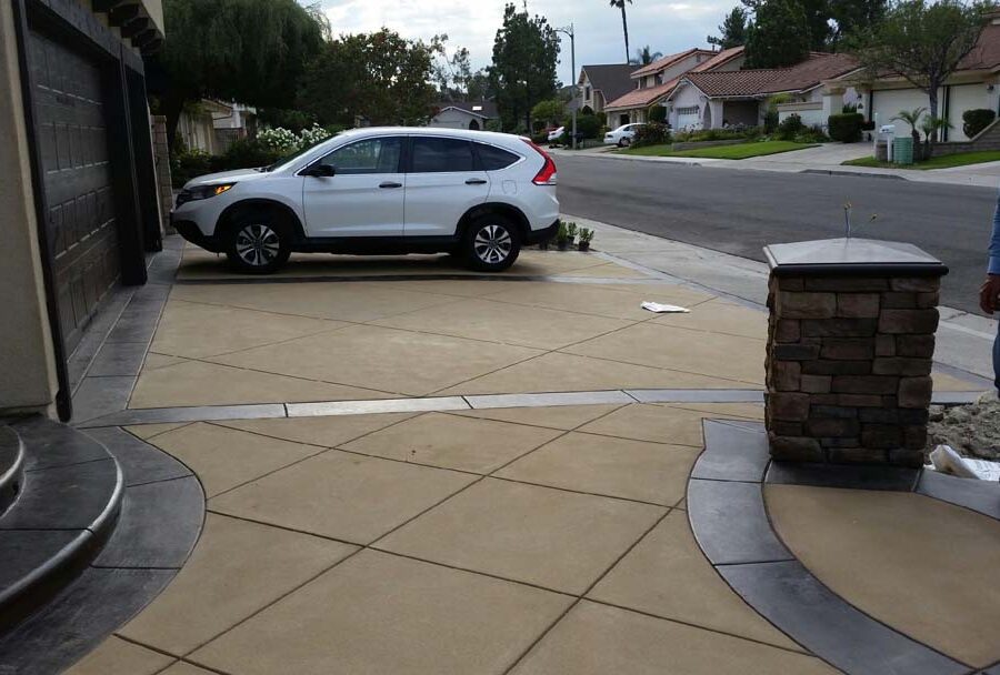 New custom entrance with colored concrete, stone covered pilasters, and concrete poured bull-nosed steps that contrast from the center of the slab. Pacificland Constructors