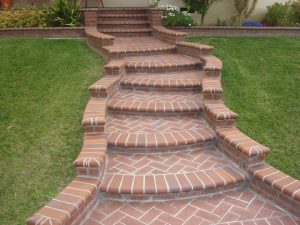 Beautiful curved walkway entrance with long brick steps and a nice brick design. The home has new brick veneer for the entrance and planters. Pacificland Constructors