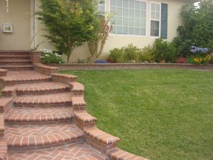 Beautiful curved walkway entrance with long brick steps and a nice brick design. The home has new brick veneer for the entrance and planters. Pacificland Constructors