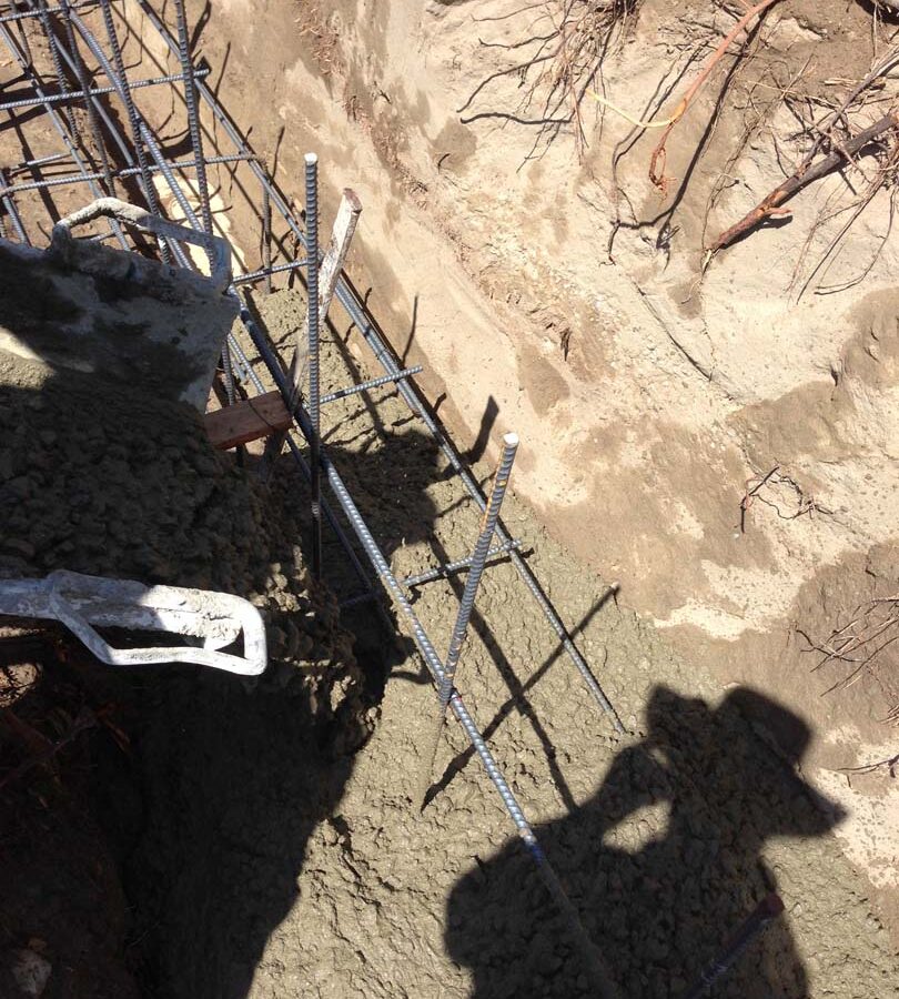 Concrete pouring of strip footings for new public works curved split-faced-block freestanding wall. Pacificland Constructors