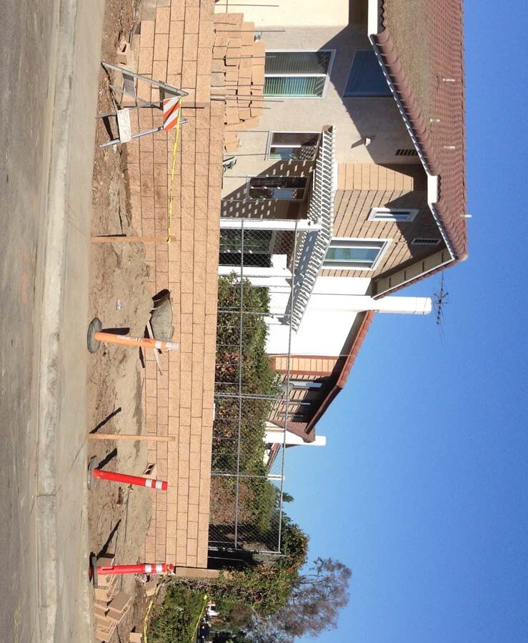 Construction of a new curved split-faced-block freestanding wall for public works. Pacificland Constructors