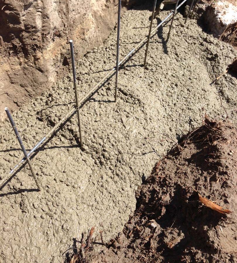 Concrete pouring of strip footings for new public works curved split-faced-block freestanding wall. Pacificland Constructors