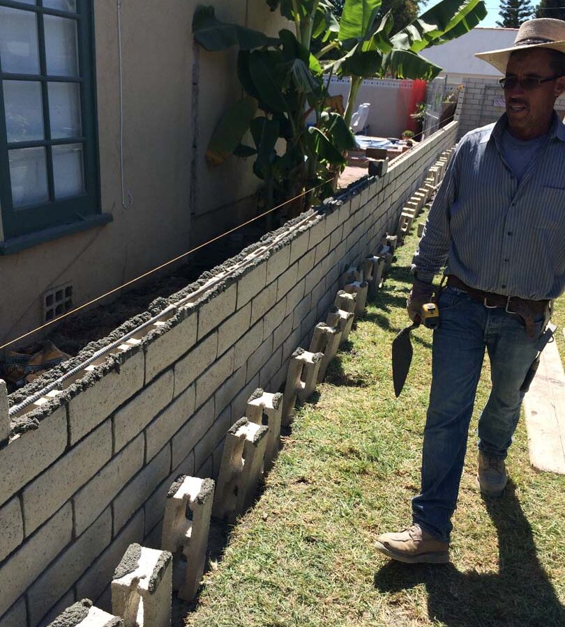 Martin, founder of Pacificland, laying slump block for a home’s side yard. This is a great option to raise the value of your home and create more private living space. Pacificland Constructors