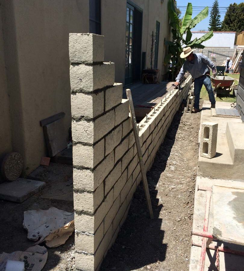 Martin, founder of Pacificland, laying slump block for a home’s side yard. This is a great option to raise the value of your home and create more private living space. Pacificland Constructors