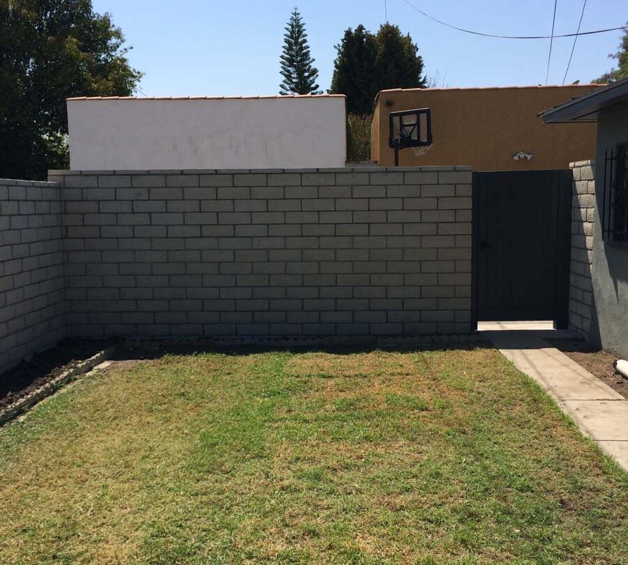 New slump block CMU wall with a wall cap for a home’s backyard. This is a great option to raise the value of your home and create more private living space. It also has access to a back alley with this wooden door. Pacificland Constructors