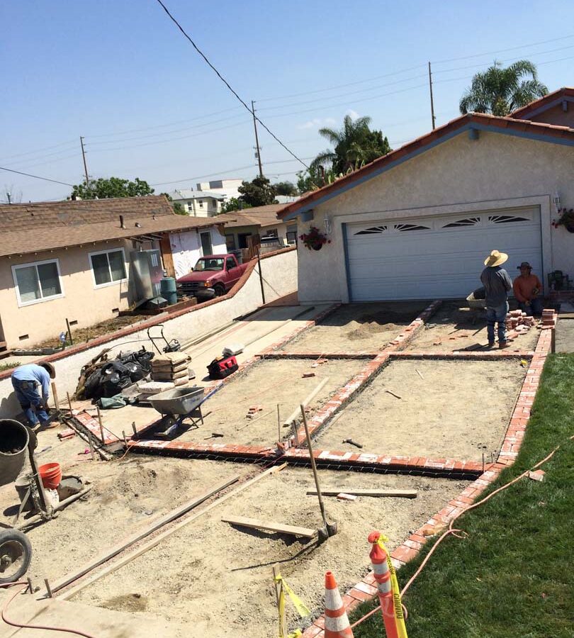 Installing new brick ribbons for a driveway. Pacificland Constructors