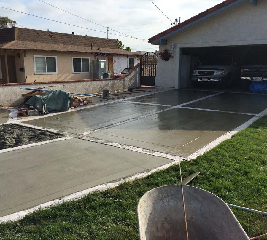 Pouring a new gray concrete driveway with brick ribbons. Pacificland Constructors