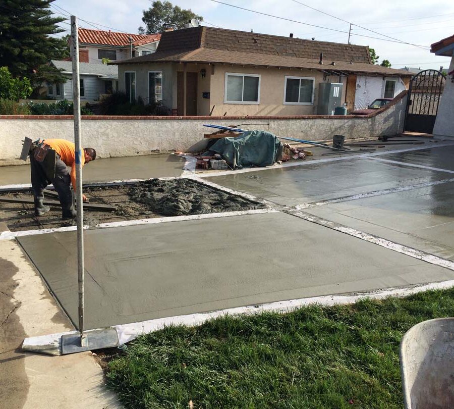 Pouring a new gray concrete driveway with brick ribbons. Pacificland Constructors