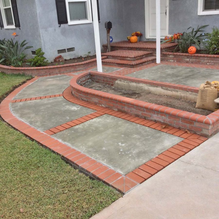 Construction of new concrete slab with brick ribbon and brick planters. Pacificland Constructors