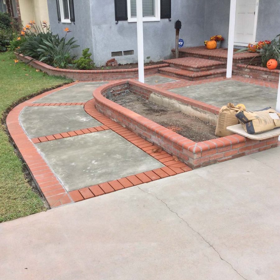 Construction of new concrete slab with brick ribbon and brick planters. Pacificland Constructors