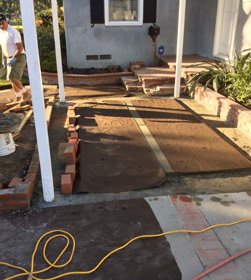 Construction of new concrete slab with brick ribbon and brick planters. Pacificland Constructors