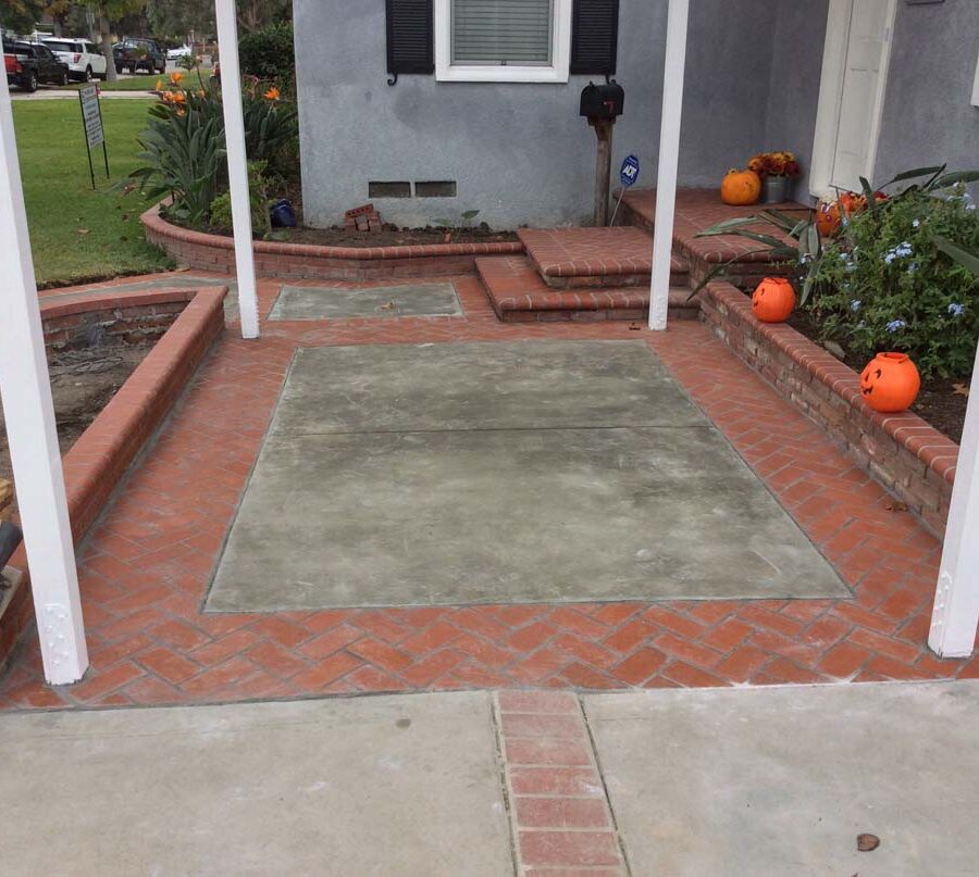 New concrete slab with brick ribbon, brick planters, and front porch. Pacificland Constructors