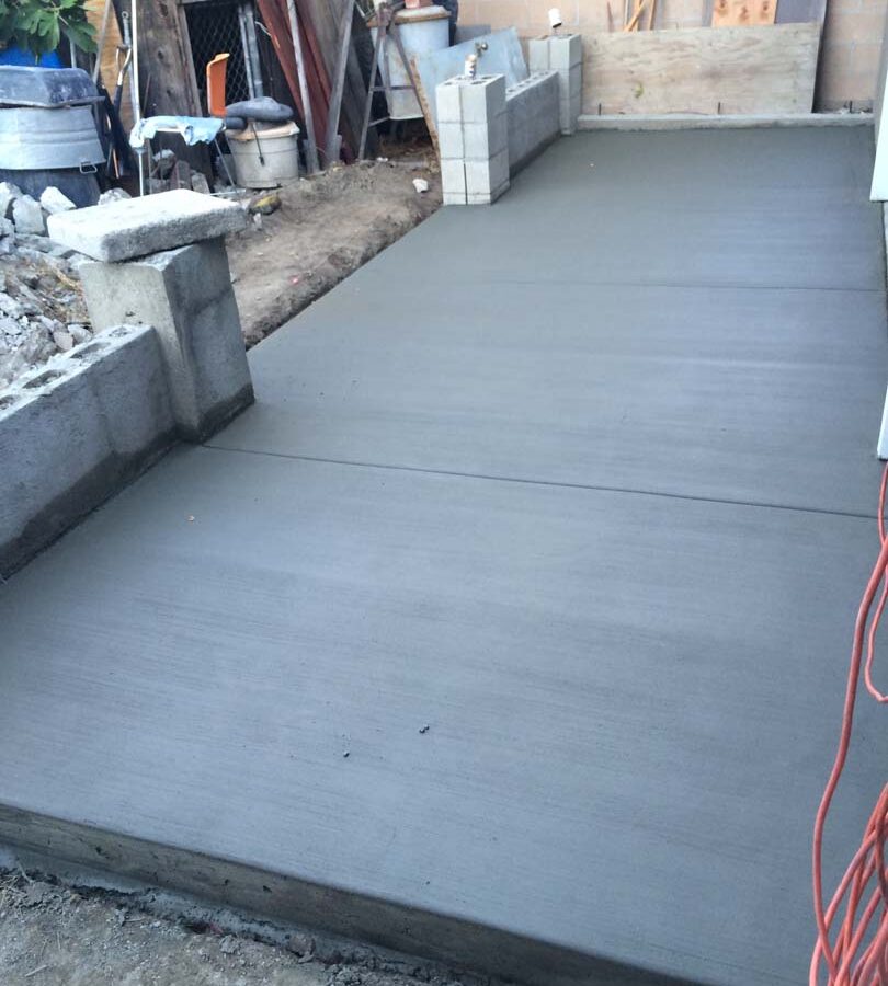 New broom swept concrete backyard patio. Pacificland Constructors