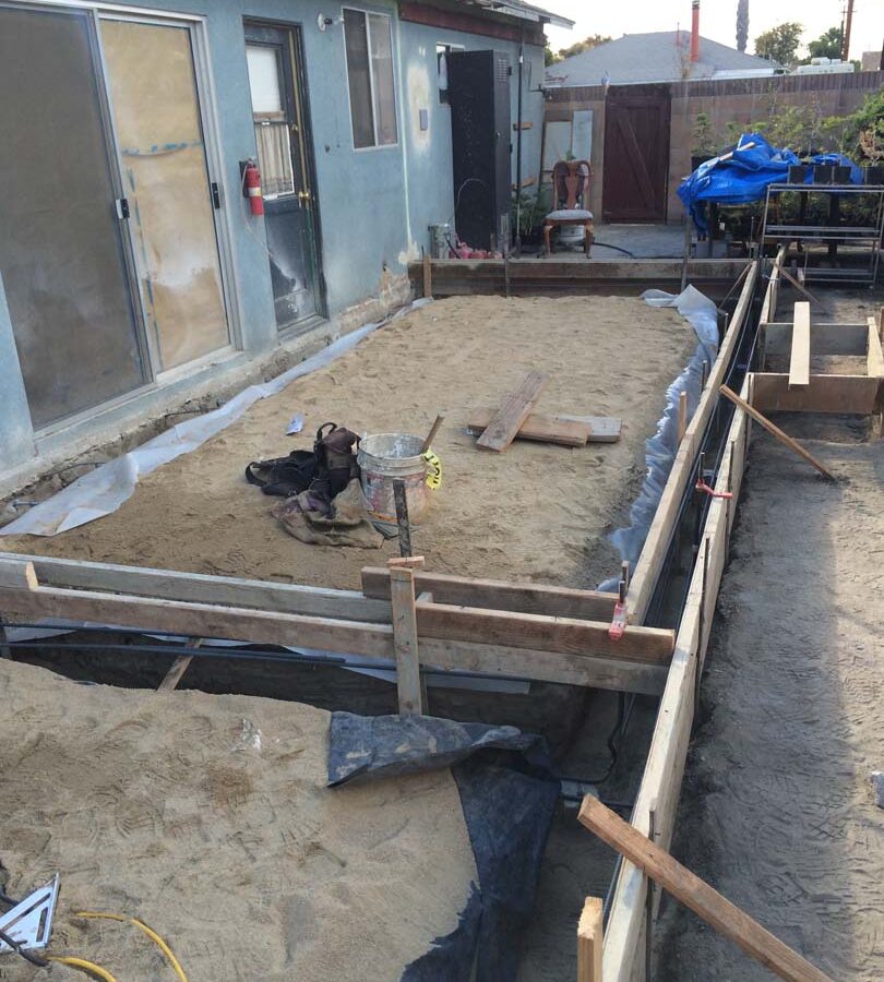 Wooden formwork and grading for a new broom swept concrete backyard patio. Pacificland Constructors