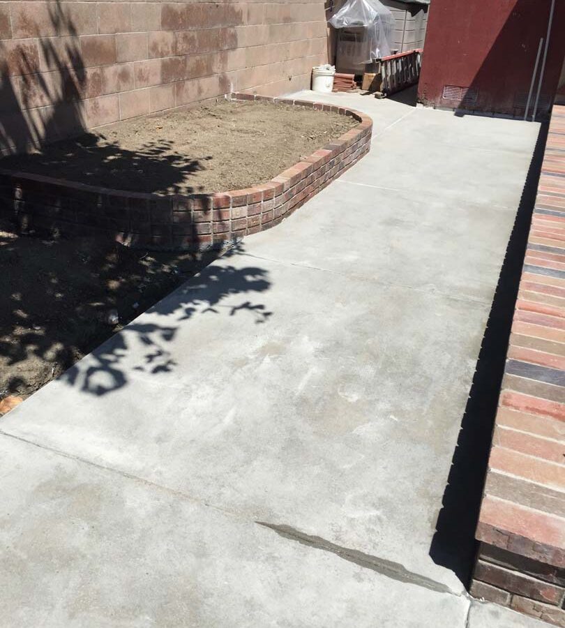 New broom swept gray walkway and brick step. Pacificland Constructors