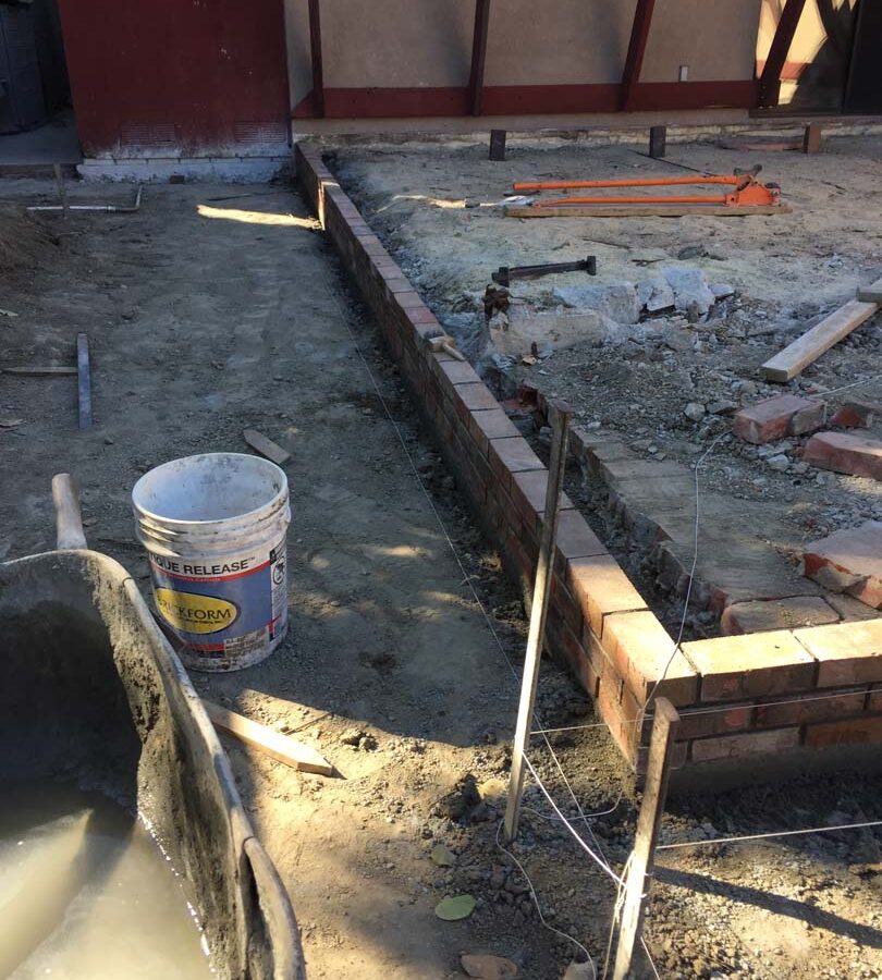 Construction of a new raised gray concrete patio. Pacificland Constructors