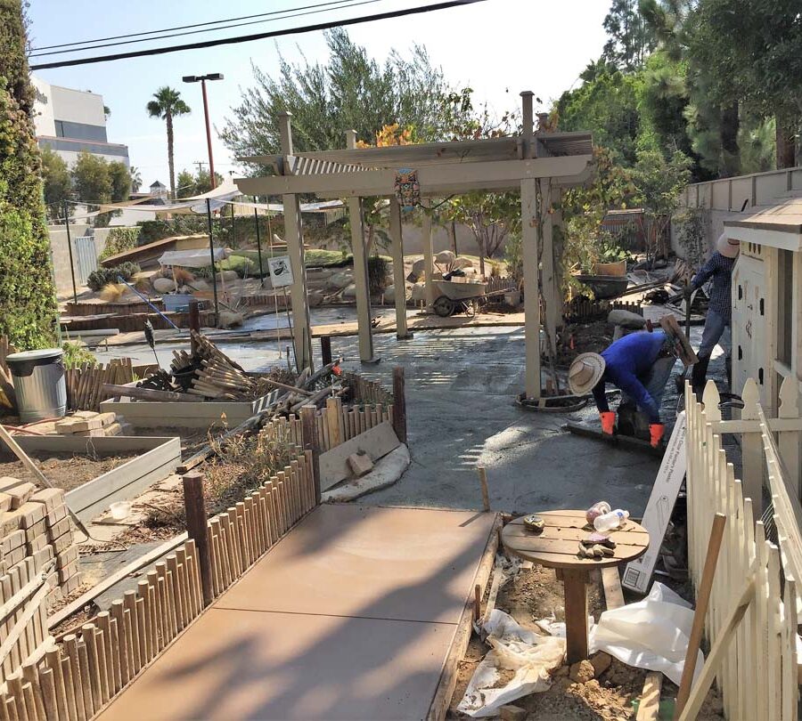 Pouring a new backyard colored concrete walkway and patio foundation for new pavers.