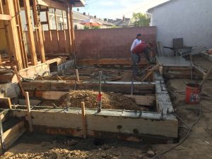 Construction for a new home addition in Lakewood, CA. Pouring of Stem wall foundation. Pacificland Constructors