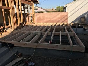 Construction framing for a new home addition in Lakewood, CA. Framing of floor joists over Stem wall foundation. Pacificland Constructors
