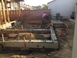 Construction for a new home addition in Lakewood, CA. Pouring of Stem wall foundation. Pacificland Constructors