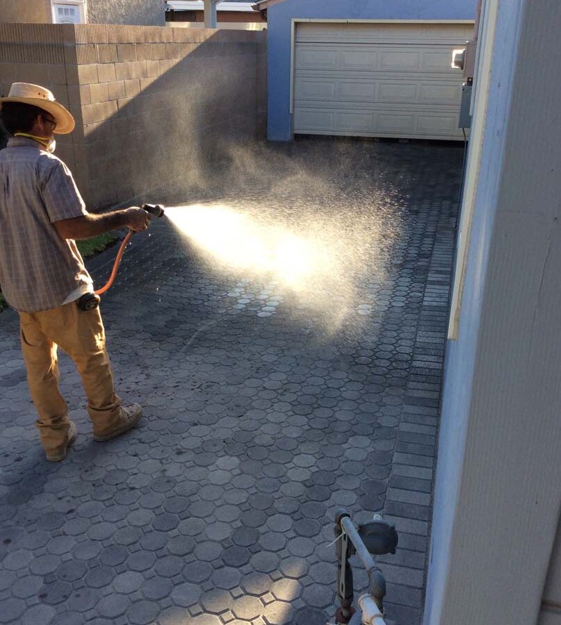 Martin, founder of Pacificland, wetting the applied silica sand so it settles between the joints of new concrete pavers for a home’s new driveway. Pavers are a great option to raise the value of your home. Pacificland Constructors