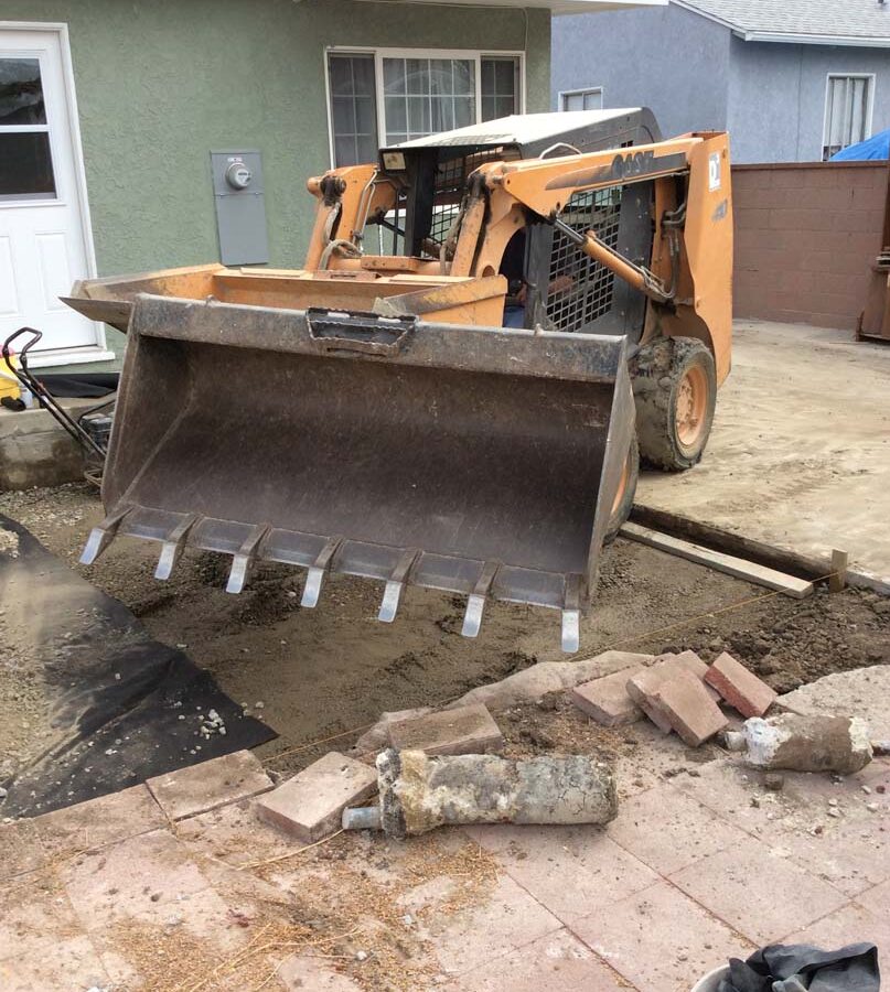 Construction equipment was used to remove the existing slap and grade the soil prior to setting up pavers.