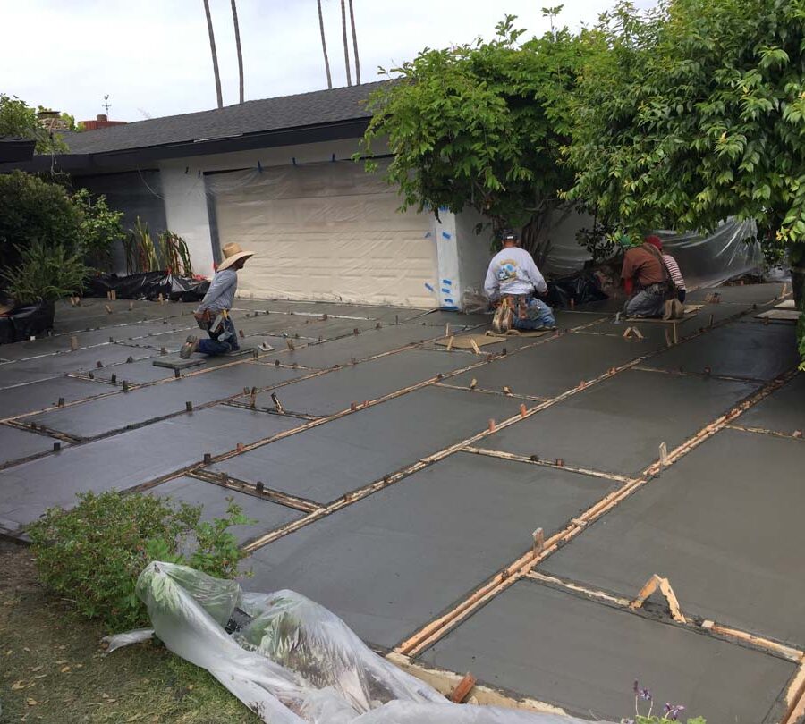 Concrete finishing a new front yard patio with gaps used to create an architecturally nature-friendly theme. Pacificland Constructors