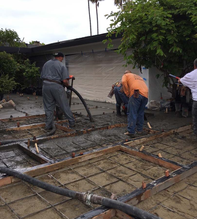 Pouring of a new front yard patio with gaps used to create an architecturally nature-friendly theme. Pacificland Constructors