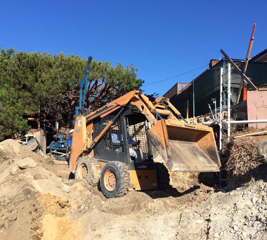 Moving soil hauled out by the machine that does the boring holes for the cast in place foundations. Pacificland Constructors