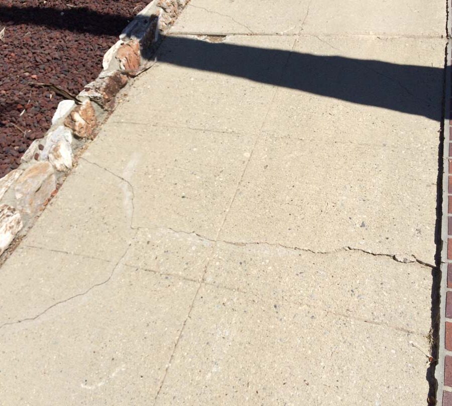 Old cracked and uneven concrete sidewalk. Pacificland Constructors